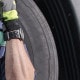 A driver leans against his truck tire as he takes a break | Rising Insurance Premiums for Transportation Firms